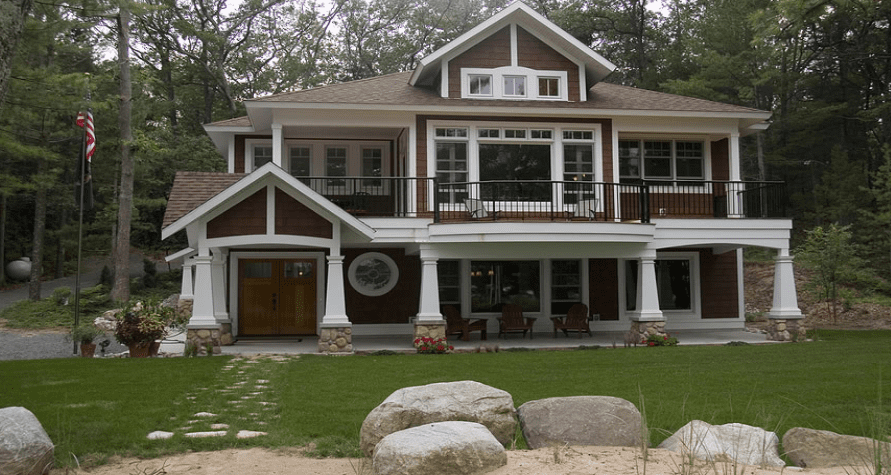 A brown two-story house with a green lawn.